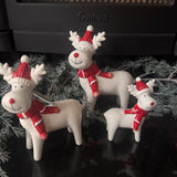 Glazed White Ceramic Reindeers wearing a Red &amp; white striped knitted Scarf &amp; matching bobble hat with a big smile &amp; red button nose
Available in 3 sizes - Small 10cm, Medium 14.5cm &amp; Large 17cm&nbsp;