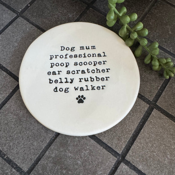 White glazed Ceramic Round Coaster 10cm with black text
Quote - 'Dog mum professional poop scooper ear scratcher belly rubber dog walker' with paw print illustration