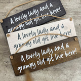 Made in the UK by Giggle Gift Co

Rectangular Wooden L29.5cm Hanging Sign
Quote - "A lovely lady &amp; a grumpy old git live here!"