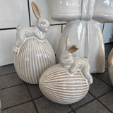 Glazed Ceramic Neutral Rabbit sat on a Ribbed Easter Egg Standing&nbsp;
Available in 2 sizes; Small 9cm &amp; Large 17cm