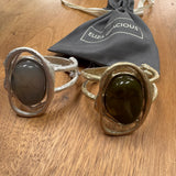 Eliza Gracious quality - affordable design led branded costume jewellery.

Hinged Bangle with large resin stone; statement piece with a beaten effect

Available in 2 colours;

Burnished Pale Gold with Olive Green resin
Matt Burnished Silver with Pale Grey resin