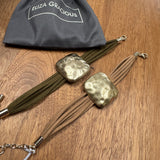 Eliza Gracious quality - affordable design led branded costume jewellery.

New SS26

Multi strand suede Bracelet with a burnished pale gold beaten square&nbsp;
Available in 2 suede colours;&nbsp; Green &amp; Beige&nbsp;