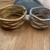 Eliza Gracious quality - affordable design led branded costume jewellery.

Wave design bangle; statement piece with a beaten effect on a hinge&nbsp;

Available in Burnished Pale Gold &amp; Matt Silver
