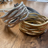 Eliza Gracious quality - affordable design led branded costume jewellery.

Wave design bangle; statement piece with a beaten effect on a hinge&nbsp;

Available in Burnished Pale Gold &amp; Matt Silver