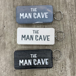 Made in the UK by Giggle Gift Co. Wooden block keyring with white text quote on both sides; 'The Man Cave' 