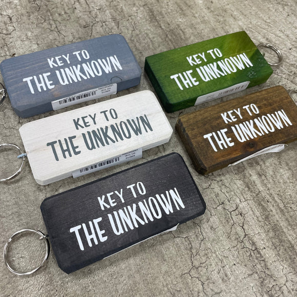Made in the UK by Giggle Gift Co. Wooden block keyring with white text quote on both sides; 'Key to the Unknown' 