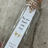 Sweet twinkle shaped earrings presented in a message bottle on a lovely card that reads "may your dreams come true" - available in gold or silver -  pictured here is gold
