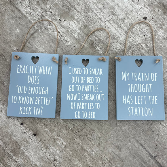 Fun Mini Hanging Signs about Getting Older! Small rectangular grey hanging signs with cut out hearts and three funny quotes!