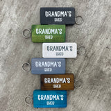 Made in the UK by Giggle Gift Co. Wooden block keyring with white text quote on both sides; 'Grandma's Shed'  in 6 colours