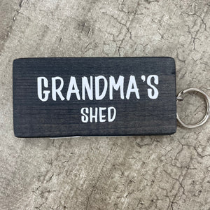 Made in the UK by Giggle Gift Co. Wooden block keyring with white text quote on both sides; 'Grandma's Shed'  in 6 colours