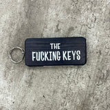 Made in the UK by Giggle Gift Co. Wooden block keyring with white text quote on both sides; 'The Fucking Keys' black