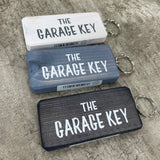 Made in the UK by Giggle Gift Co. Wooden block keyring with white text quote on both sides; 'The Garage Key' 