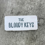 Made in the UK by Giggle Gift Co. Wooden block keyring with white text quote on both sides; 'The Bloody Keys'  White