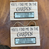 Rotating Wooden Sign; You'll find me in the garden... One side 'With a Drink in my hand' Other side 'Down on my knees weeding' Item no: 63651