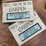 Rotating Wooden Sign; You'll find me in the garden... One side 'With a Drink in my hand' Other side 'Down on my knees weeding' Item no: 63651