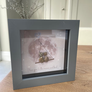 Mini Framed Pebble Art - Grey block square frame 12.5cm;With a soft background image of the world and a swing seat with two pebble people: you and your dad sitting together with the quote 'Dad' at the top in a blue heart and at the bottom 'I love you to the moon and back' 