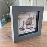 Mini Framed Pebble Art - Grey block square frame 12.5cmThe background is fun with a pink scooter with two pebble friends sitting on it toasting with prosecco with the quote 'We'll be friends til we're old and senile...Then we'll be new friends!'