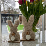 Natural soft Sherpa Easter Rabbits stood on a wooden base so a simple & cute decoration