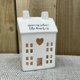 White Ceramic T Light House with battery T-Light included reading the quote: "Home is where the heart is"